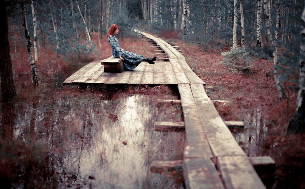 Conscious living in Cornwall — woman sitting peacefully among autumn trees
